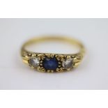 A Victorian style blue sapphire and diamond 18ct yellow gold three stone boat head ring, the central