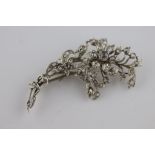 A diamond silver floral spray brooch comprising fifty-three rose cut diamonds, the principle diamond