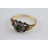 A 19th century emerald and diamond unmarked yellow gold and silver set cluster ring, the centre