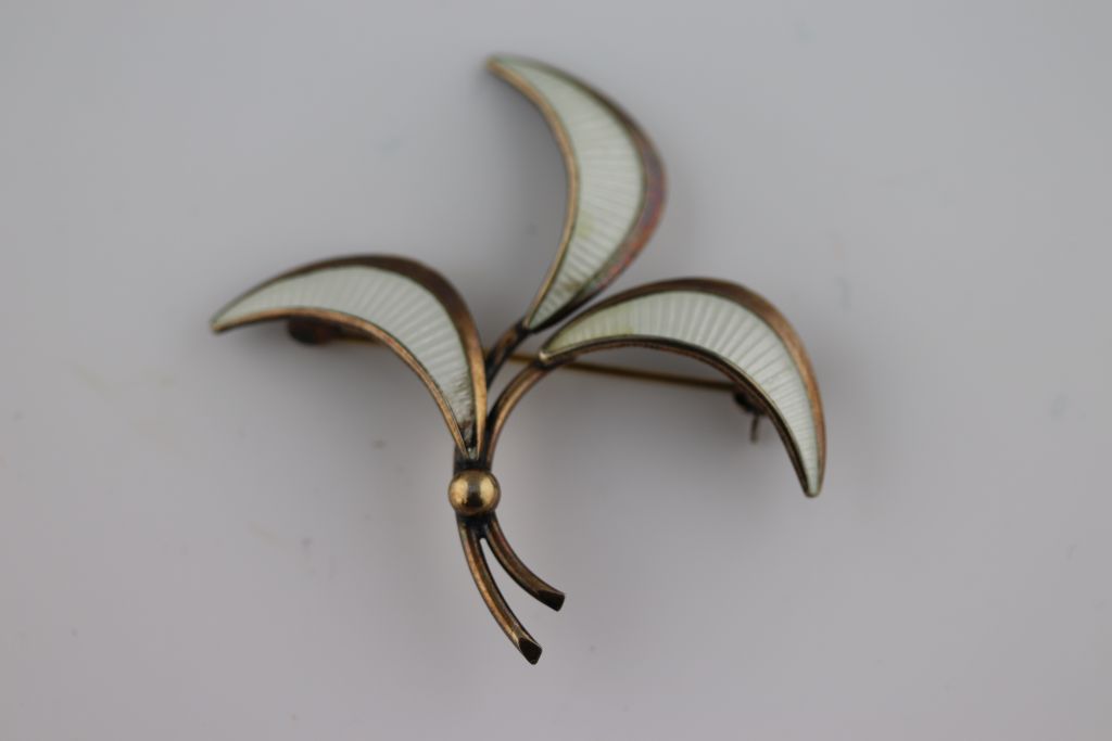 A Scandinavian style enamelled silver gilt vintage three leaf brooch, white enamelled leaves (some