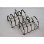 A pair of silver five bar toast racks, trapezoid form with fluted base, height approximately 8cm,