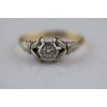 A diamond solitaire 18ct yellow gold and platinum set dress ring, the central illusion set round