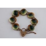 An operculum 9ct rose gold padlock clasp bracelet, seven oval rub over set operculum panels with