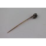 A Victorian diamond unmarked rose gold and silver set horseshoe shaped stick pin, nine graduated old