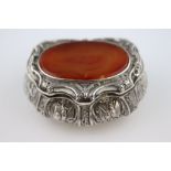A continental 925 silver and carnelian agate Rococo style snuff box, the bombe form with embossed