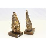 A pair of angel wing bookends on wooden bases