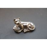 Cast silver cat seated with emerald eyes