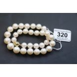 A fine graduated row of baroque pearls set with a 9ct yellow gold clasp