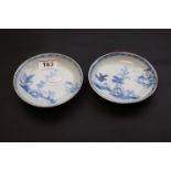 A pair of Japanese blue and white 18th century small plates, circa 1750, depicting landscape