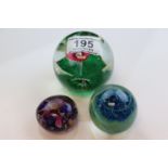 Three paperweights, assorted sizes, one with trumpet flowers (3)