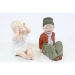 Two Piano style ceramic babies, one in Dutch outfit