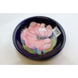 Moorcroft magnolia dish, blue ground with pink central magnolia, impressed marks and signed to