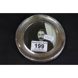 An Edwardian circular silver photograph frame containing black and white photograph of an