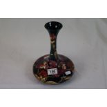 Moorcroft vase, the base of flattened circular form with slender tapered elongated neck, green and