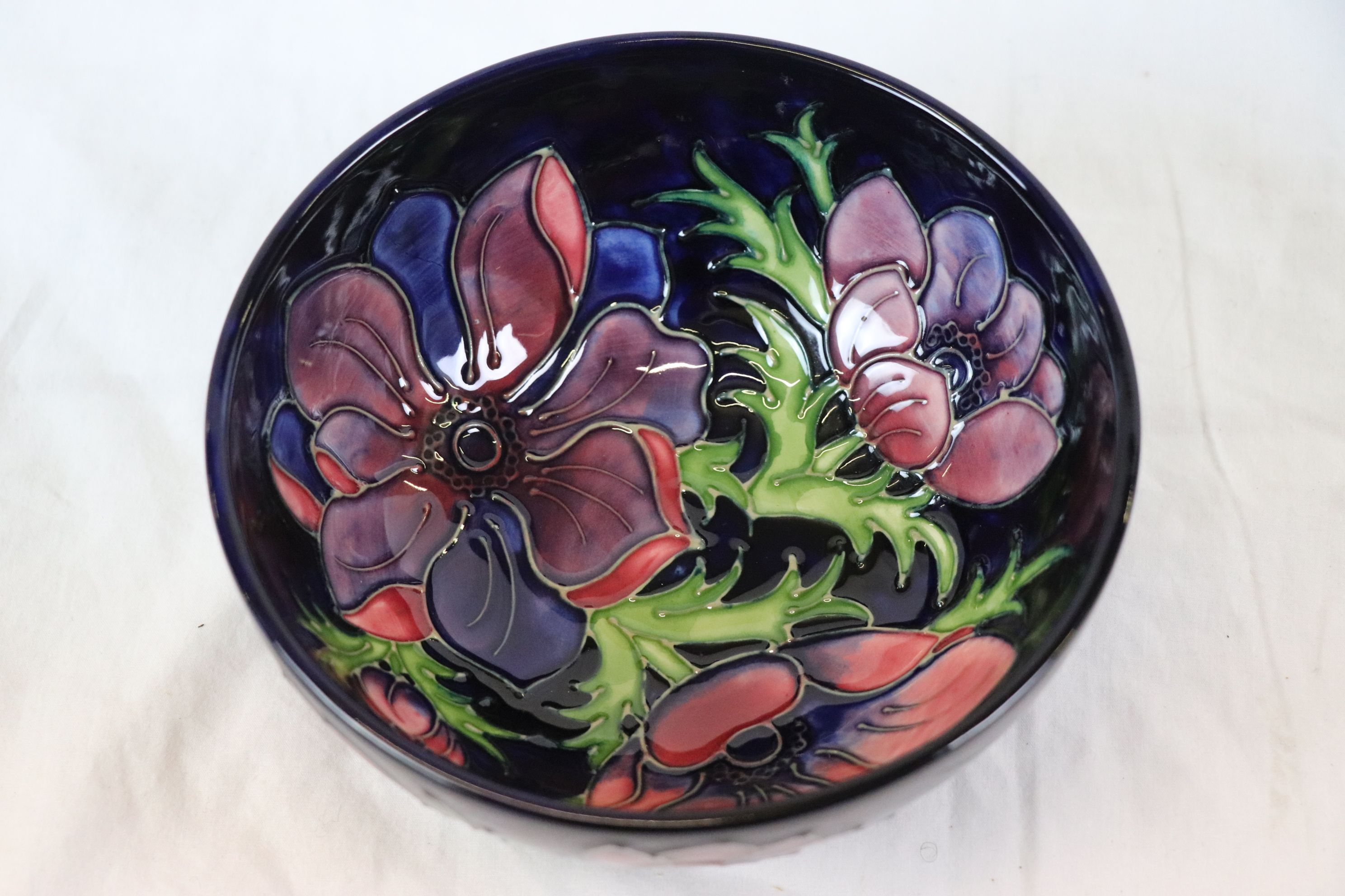 Moorcroft anemone pattern bowl, blue ground with red and purple anemone decoration, impressed and