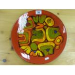 Large Poole Pottery Delphis charger, red ground with green, yellow, orange and blue abstract