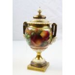Royal Worcester twin handled hand painted urn with ogee shaped cover raised on square foot, fruit