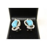 A pair of silver CZ and turquoise paneled earrings.