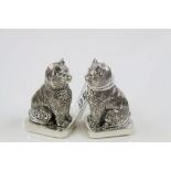 A pair of 800 silver condiments in the form of cats with emerald eyes.