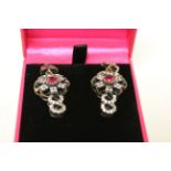 A pair of silver and renaissance style earrings with CZ's and ruby panels.