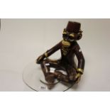 Model of a Monkey wearing a Fez and holding a Glass Bowl together with a Hanging Model of a Gold