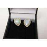 A pair of silver CZ and pear shaped opal earrings.
