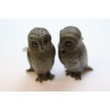 A part pewter owl cruet set comprising mustard and pepper, the owls with paste eyes and textured