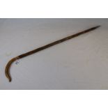 Wooden walking stick with a crook style handle and spike end