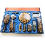 A cased tortoiseshell style brush and dressing table set, engraved with dragon decoration