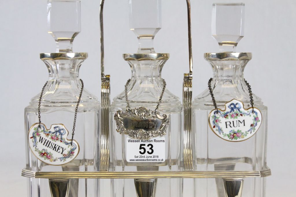 Silver plated three bottle Tantalus with original bottles, two with ceramic labels, the other with a - Image 2 of 4