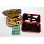An Art Deco enamelled case travelling manicure set with green bakelite handles, a cased sewing kit