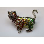 A silver plique a jour brooch in the form of a cat with ruby eyes and collar