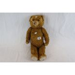 Early 20th C straw filled teddy bear, showing some wear, with both eyes, 21" in approx height