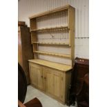 Large Pine Dresser, the opening graduating shelves with cup hooks above two panel cupboard doors (