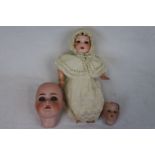 Bisque head doll numbered 210, socket bisque head with closing blue eyes, open mouth with two