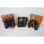 Three pairs of binoculars all in leather carrying cases