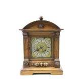 Bracket style Wooden cased Mantle clock with German Patent movement, the dial surrounded by winged