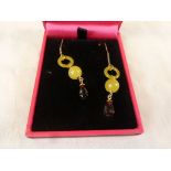 Pair of yellow gold drop earrings with yellow stone and garnets