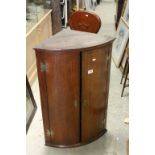 Georgian Oak Bow Fronted Hanging Corner Cabinet, the two panel doors opening to reveal three