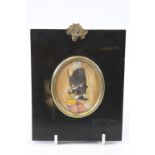 A silhouette of a military man, heightened in watercolour in rectangular frame, acorn finial,