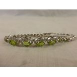 Silver bracelet made up of four peridot and CZ panels
