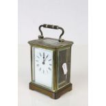 20th century Brass Cased Carriage Clock, the four section glass case with swing handle, the white