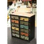 A vintage hand painted decorated miniature chest of 12 drawers.