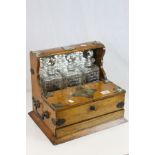 Oak cased Three bottle Tantalus, with bottles, integral Drawer and compartments, case has Silver