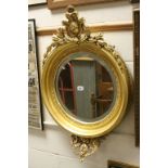 19th century Carved Giltwood Circular Bevelled Edge Mirror surmounted by scrolling leaves, total