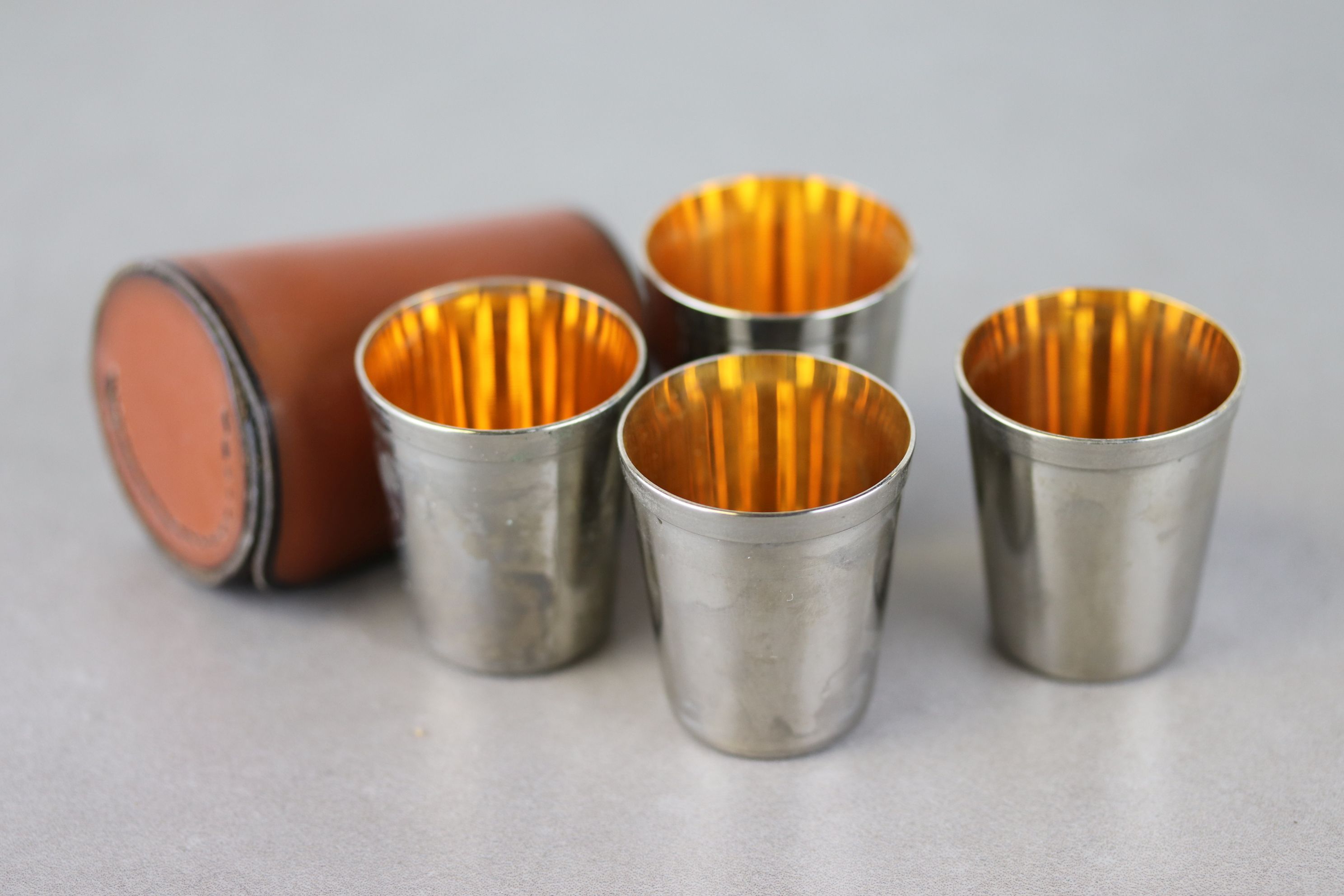 Set of Four White Metal Stacking Hunting / Stirrup Cups with Gilt Interiors contained in a Leather
