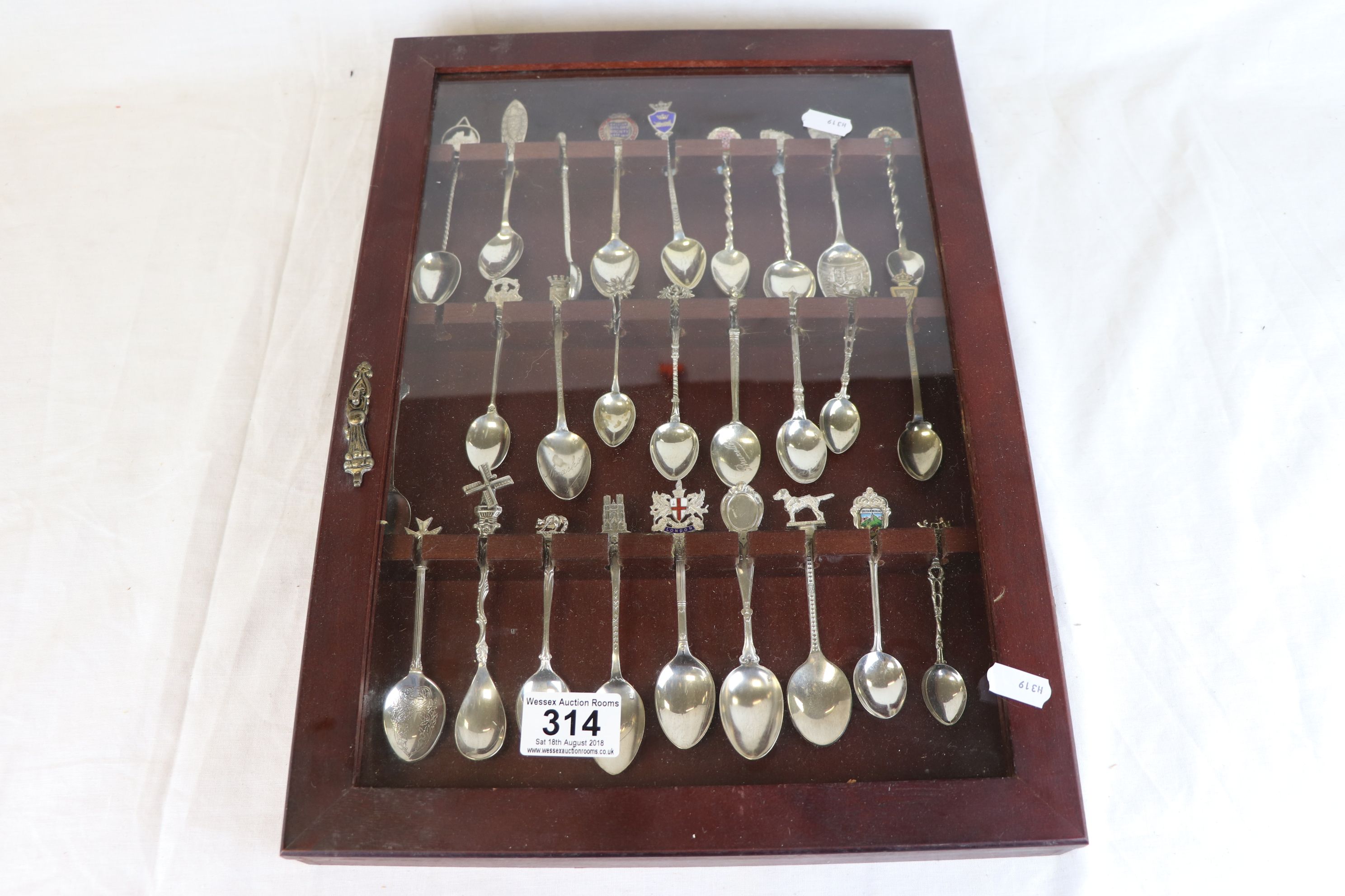 Souvenir teaspoons, some with enamelled finials, approximately 27 in total contained within display