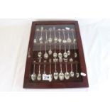 Souvenir teaspoons, some with enamelled finials, approximately 27 in total contained within display