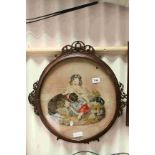 An antique oval rosewood frame containing woolwork tapestry of girl with dog and cat.