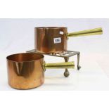 Two Copper Saucepans with Brass Handles with a Brass Stand with Lion Paw Feet